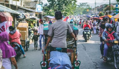 Energietransitie in Indonesië: een typische drukke straat met brommers, tuk-tuks en wandelende mensen langs marktkramen