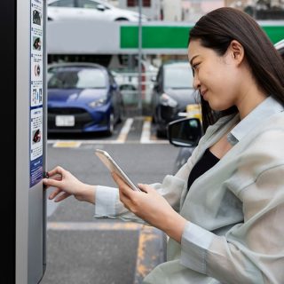 Dame sluit haar elektrische auto aan op een laadpaal