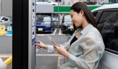 Dame sluit haar elektrische auto aan op een laadpaal