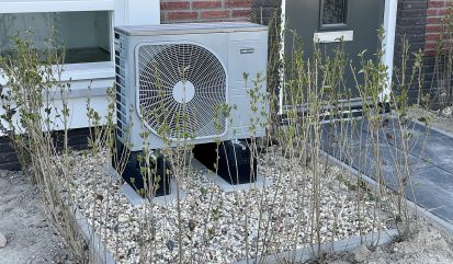Warmtepomp in de voortuin van en woonhuis