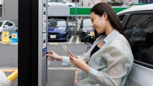 Dame sluit haar elektrische auto aan op een laadpaal