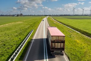 Vrachtwagen op de weg met in de verte windmolens