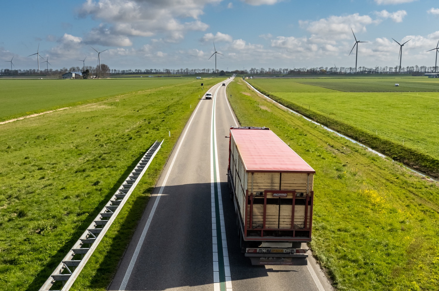 Vrachtwagen op de weg met in de verte windmolens