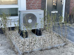 Warmtepomp in de voortuin van en woonhuis